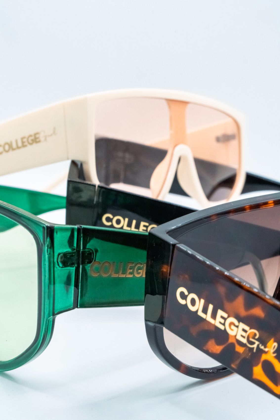 College Gurl sunglasses stacked, showing the gold logo on the arms